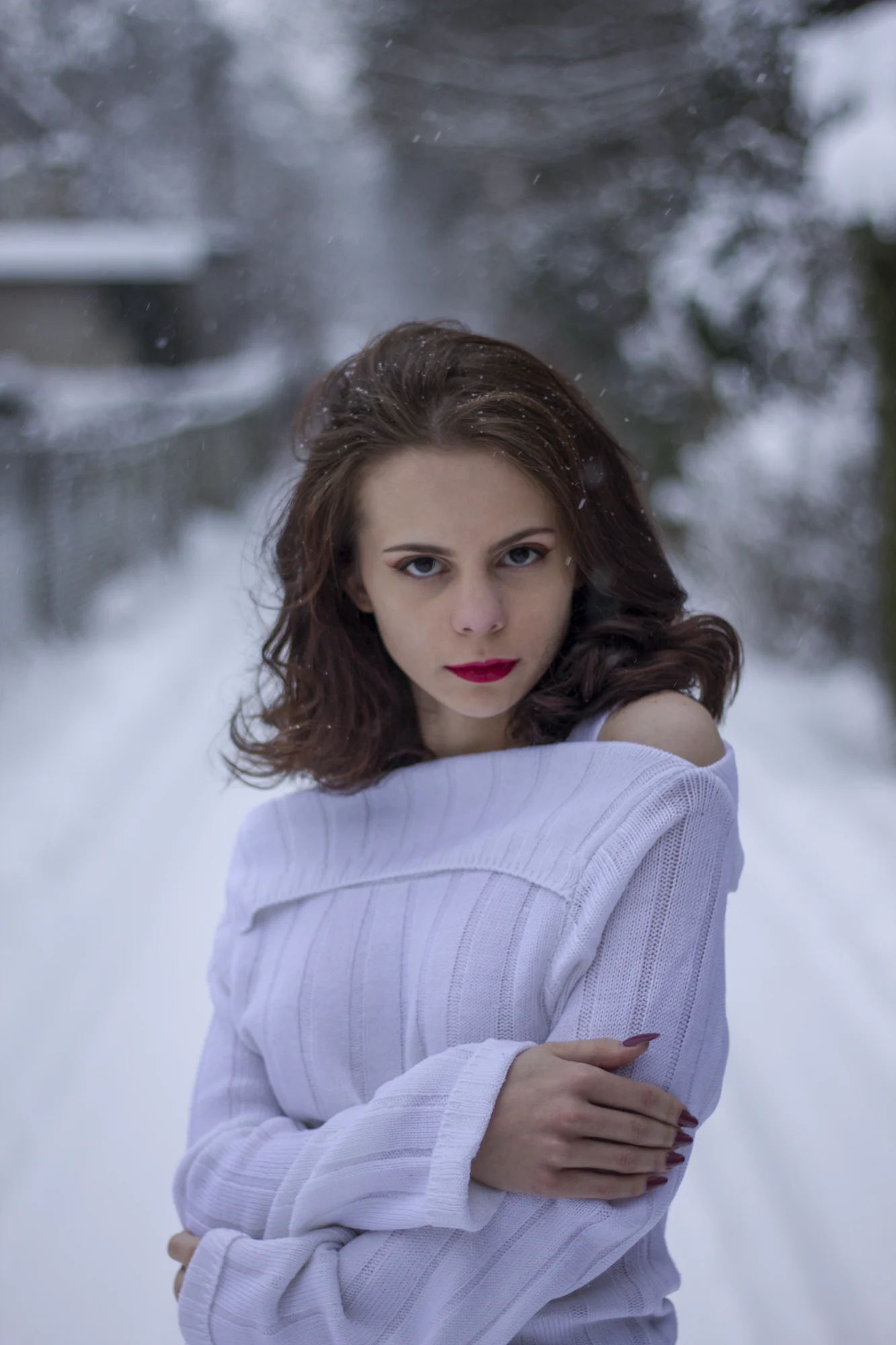 Portret kobiety w zimowej scenerii, z bukietem kwiatów